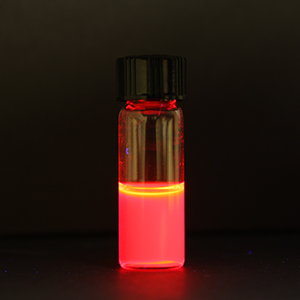 The hybrid crystal fluorescing brightly in solution.