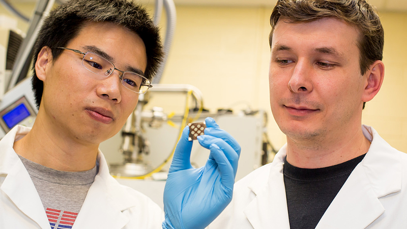 Co-authors Zhijun Ning (left) and Oleksandr Voznyy (right) examine a film coated with colloidal quantum dots (credit: Roberta Baker).
