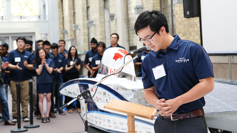 Managing Director Zhe Gong, foreground, announces the new vehicle.