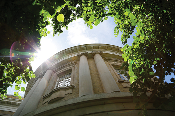 Sun peeks through the trees above the Sandford Fleming Building.