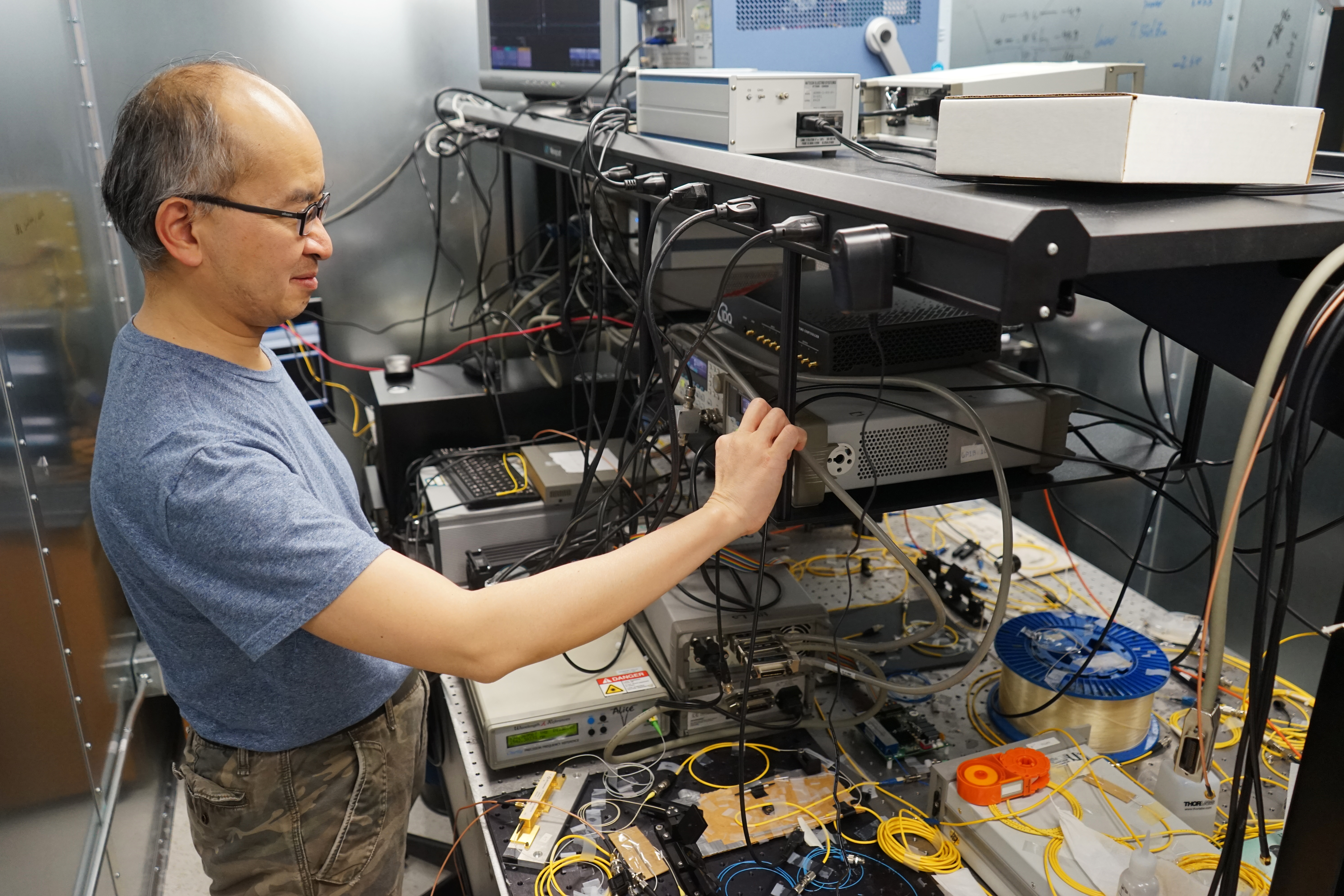 Professor Hoi_Kwong Lo works on an experiment in his lab.