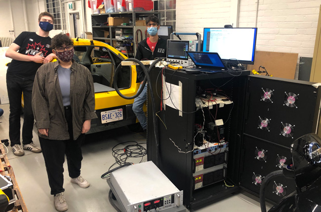 Team members (from l-r) Dylan Lamont, Michelle Tessy and Seif Sarofim (all Year 4 ElecE) prototyped a battery-assisted DC fast charger (black cabinet), which they successfully tested on a Nissan Leaf. The annual Design Fair, virtual for 2021, presents all fourth-year undergraduate Capstone projects from the past year.