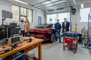 Professor Olivier Trescases (far right) stands in the University of Toronto Electric Vehicle Research Centre with (left to right) PhD Candidate, Zhe Gong; Wendy Baker, Associate Director Business Development, School of Continuing Studies; and Nick Cusimano, Research Associate.