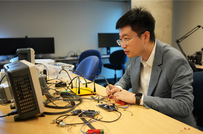 Professor liu in his lab before electrical testing equipment