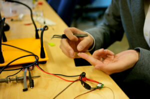 Tiny chip held up by an index finger in electronics lab