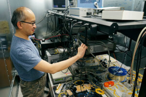 Professor adjusting dial on lab equipment