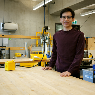 Student standing behind tall desk in design lab
