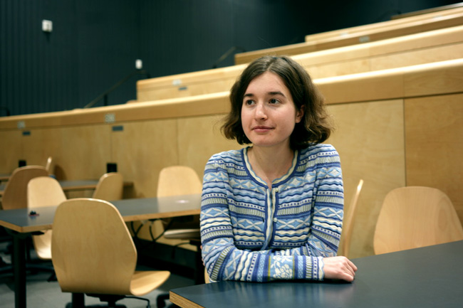 Smith seated in lecture hall looking off-camera
