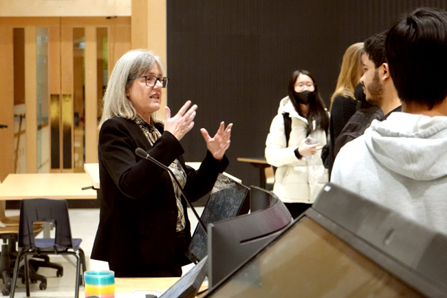 Strickland gesturing with hands as she stalks to gathered students
