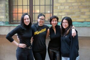 Four students with arms draped on shoulders in Bahen atrium