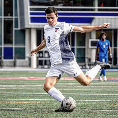 Soccer player kicking a ball on the pitch