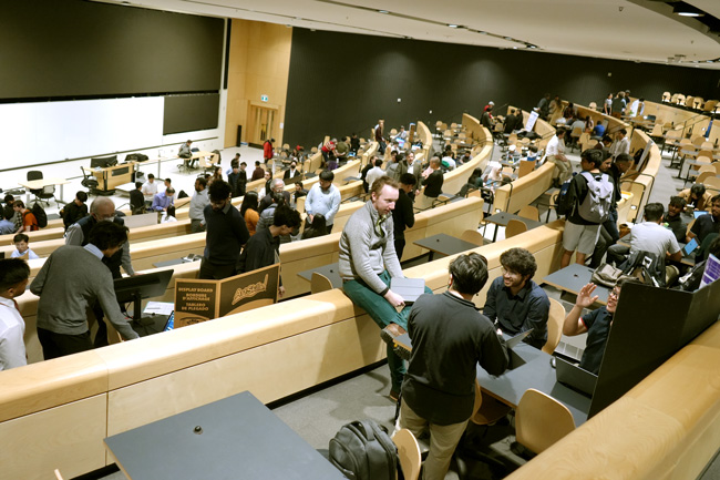 A crowd of people seen from the back fo the lacture hall