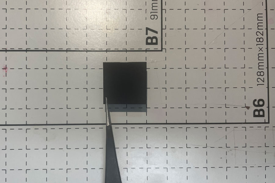 Small, black chip on grid