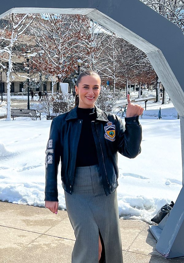 Poirier in winter jacket with little finger raised to show the iron ring for engineers.