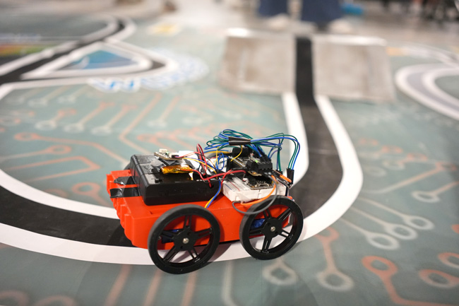 Close-up of red, car-like robot on a track curve