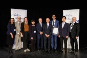 People in a row, smiling at the camera, holding certificates