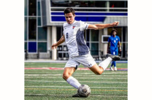 Man about to strike a soccer ball on the field