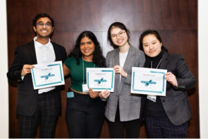 Recipients holding certificates, smiling at camera