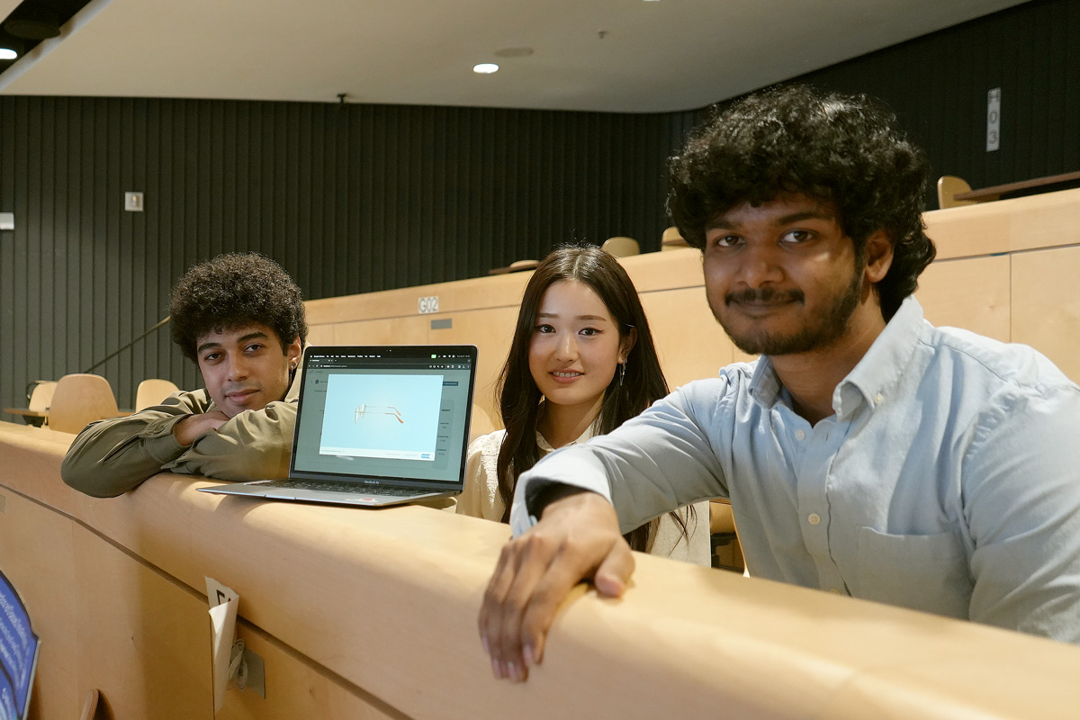 Three students around a laptop showing virtual glasses