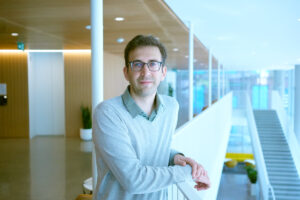 Professor leaning on railing over second floor lobby