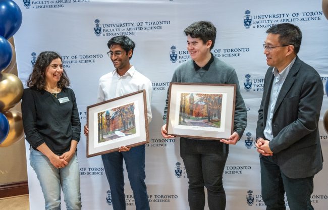 Students holding framed awards with the Dean smailing alongside